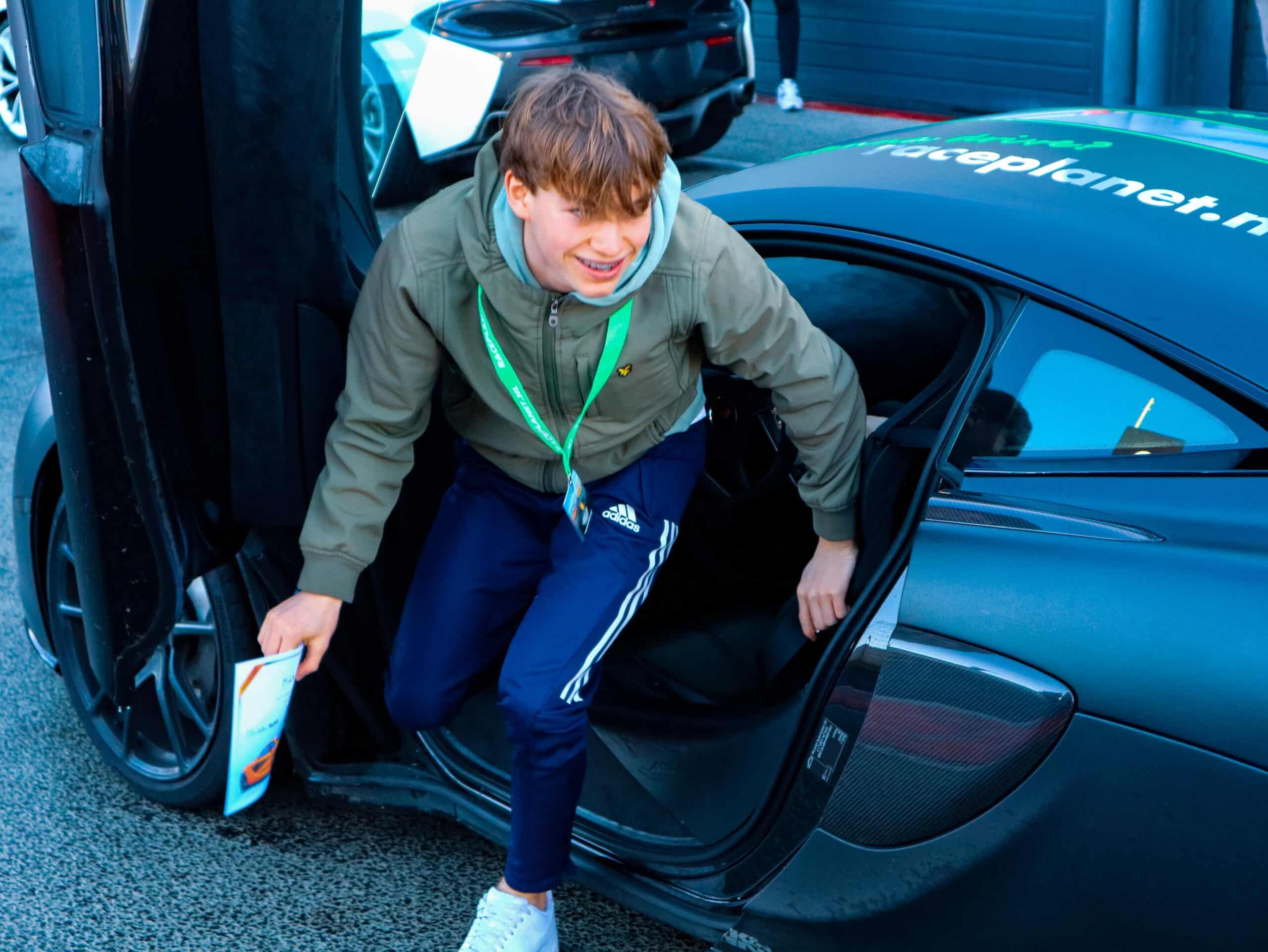 Enthousiaste deelnemer aan het Jeugdrijden stapt uit de auto