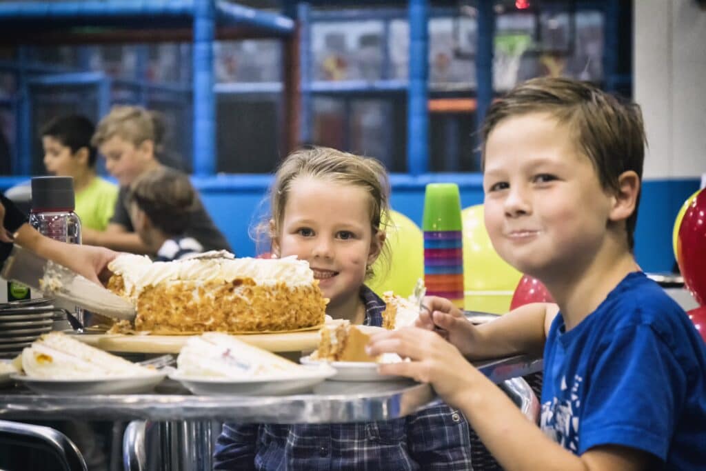 Kinderen smullen van een taart tijdens een kinderfeestje bij Jimmy's Speelparadijs in Amsterdam