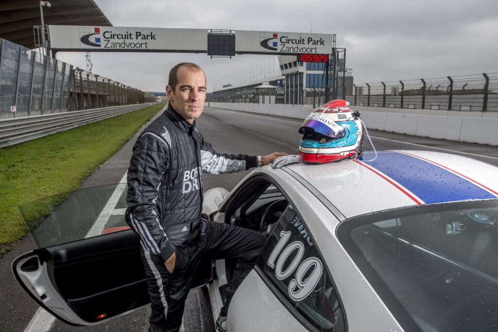 Coureur Jeroen Bleekemolen naast een Race Planet Porsche 911 op Circuit Zandvoort.