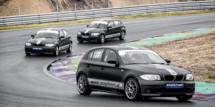 BMW 1-series op Circuit Zandvoort in de bocht, met deelnemers zelf achter het stuur tijdens een Race Experience van Race Planet