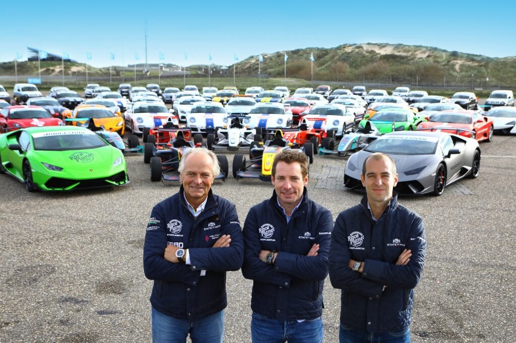 Michael, Sebastiaan en Jeroen Bleekemolen staan voor het wagenpark met supercars van Race Planet op Circuit Zandvoort